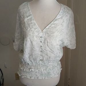 Dolman sleeve top with buttons and ruching.